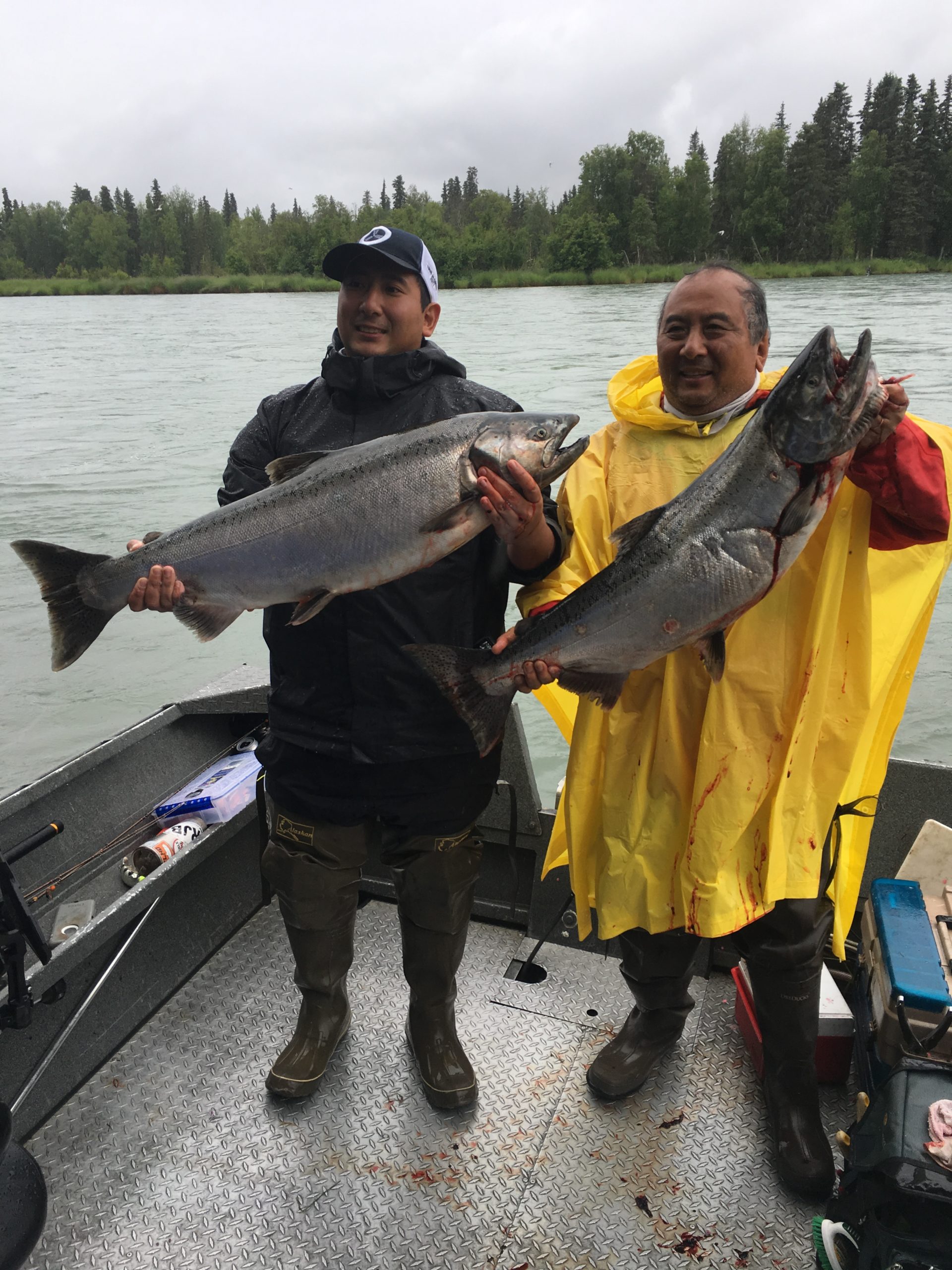 Two men holding salmon
